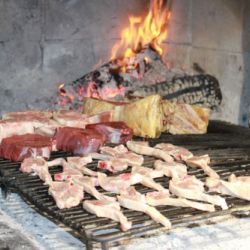 Parrilla encendida con varios tipos de carnes en Restaurante Venta San José en Zafra de Záncara